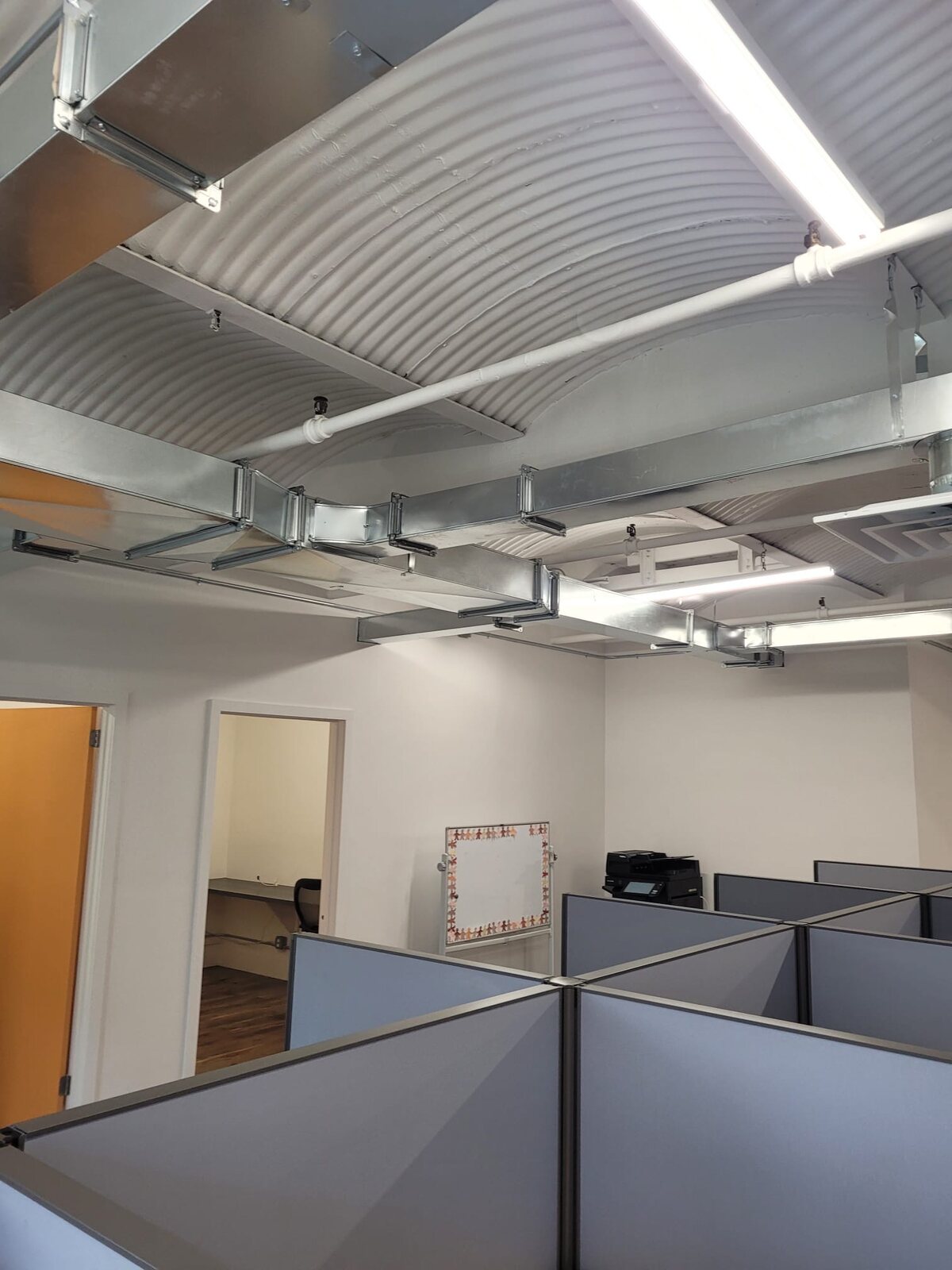 Exposed rectangular ductwork installed above an office